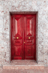 Fototapeta na wymiar Old red double door in Hydra town, Greece.