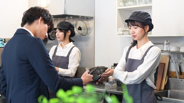 キャッシュレス決済をする若い男性客