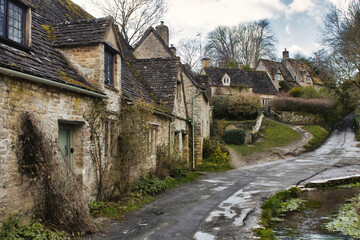 Fototapeta na wymiar A row of stone cottages / houses in a typical rural village in the touristic Cotswolds region of England, UK with no people