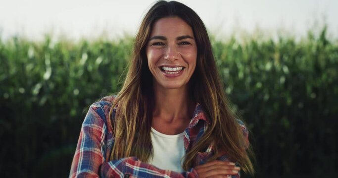  Portrait of a Cheerful Young Woman Looking at the Camera with a Greenery Background. Female Farm Worker Happy with her Role in an Environment-friendly Small Business. Ecological Project Concept