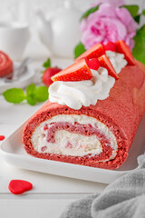 Red velvet rolled cake with fresh strawberries and cream cheese. Valentine's Day dessert. Selective focus.