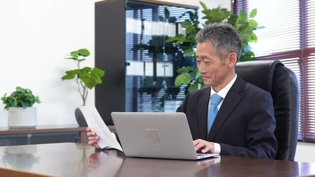社長室で仕事をするシニアの男性