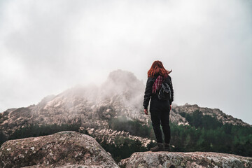 young traveler stands in front of a mountains