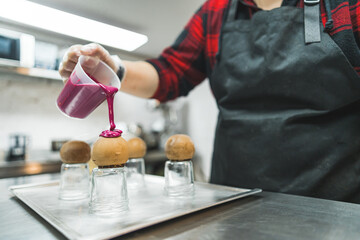 decorating chocolate balls with pink cream in the bakery, dessert concept. High quality photo