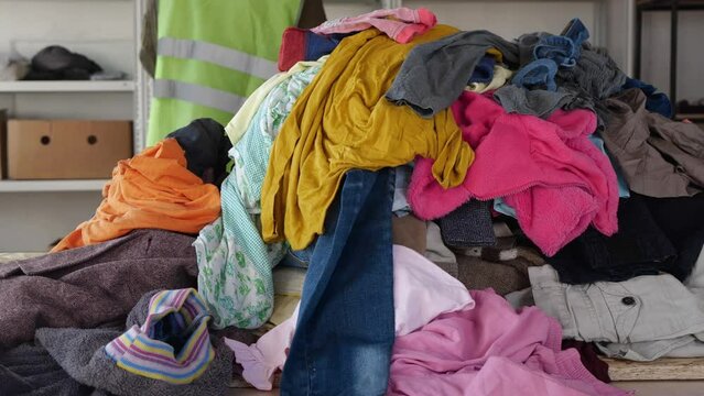 Young volunteer working for a charity, donating apparel to needy people. Donation center. Donating, recycling, or reusing old clothes