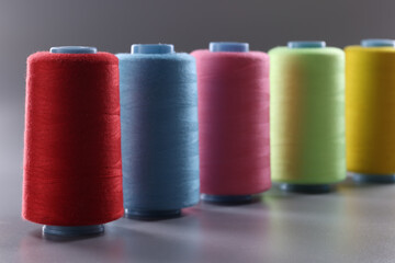Multicolored thread spools on gray background. Set of colored threads