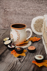 Small chocolate candies and cup of coffee on vintage wooden table