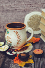 Small chocolate candies and cup of coffee on vintage wooden table