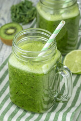 Smoothie in mugs of green cabbage, kiwi and lime.