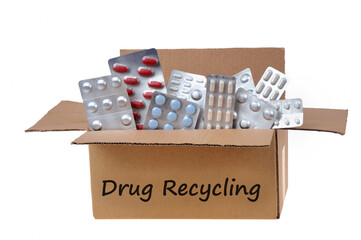 Blister packs of drugs for recycling in an open cardboard box close-up on a white background | Blisters de médicaments à recycler dans un carton ouvert en gros plan sur fond blanc