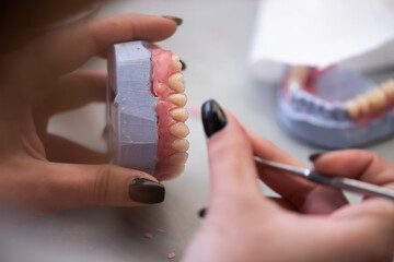 Obraz premium Dental technician works by brush with jaw model. Facial Dental Prosthetic