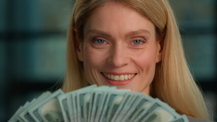 Caucasian rich middle-aged adult woman close up headshot female face with banknotes fan of money indoors. Winner mature lady businesswoman holding business cash profit finance dollars smiling happy