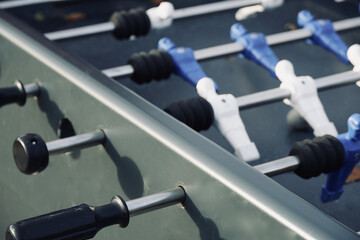 Playing foosball soccer in the park. Outdoors children activity. Figures of a foosball table in...