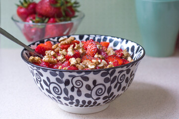 Strawberry salad with walnuts and poppy seeds in a black and white plate