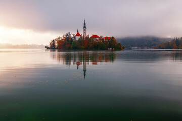 Lake Bled in morning lights, foggy beautiful sunrise, popular tourist spot in Julian Alps, Triglav...