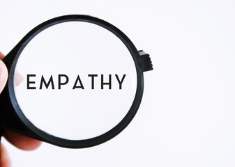 Magnifying glass on white copy space background , focus on text EMPATHY, ability to understand...