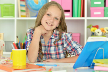 little girl studying at home at the table