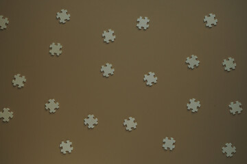 Flat blank wooden puzzles on brown background view from above. Festive background for a congratulatory inscription. New Year, Christmas, Valentine, Birthday. Blurred background