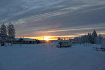 Wooden snow houses at beautiful orange sunset