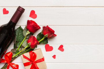 Valentine's day composition with red wine, rose flower and gift box on table. Top view, flat lay. Holiday concept