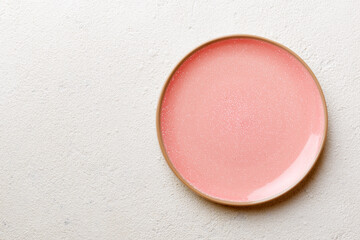 Top view of empty pink plate on cement background. Empty space for your design