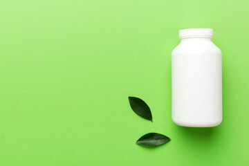 supplement pills with medicine bottle health care and medical top view. Vitamin tablets. Top view mockup bottle for pills and vitamins with green leaves, natural organic bio supplement, copy space