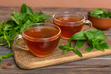 Cup of mint tea on table background. Green tea with fresh mint top view with copy space