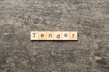 tender word written on wood block. tender text on table, concept