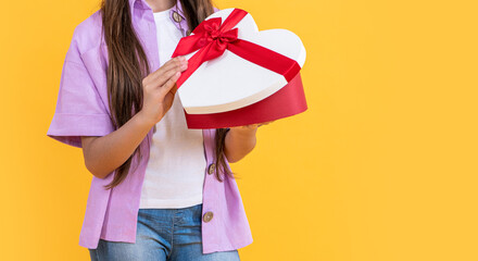 cropped view of teen girl with birthday gift isolated on yellow, copy space. teen girl