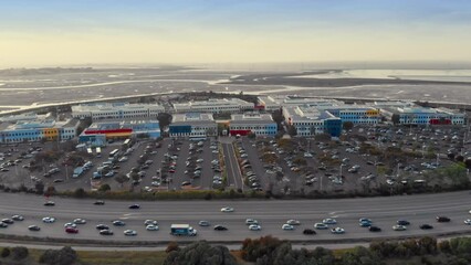 Aerial view of the Facebook Meta headquarters. Shows the office building, freeway traffic, and surrounding wetlands. Menlo Park, California, USA. 