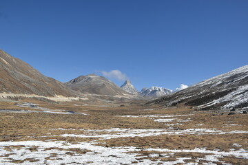 Panoramic landscape view of beautiful snowcapped Zero Point, or Yumesamdong, and distant Himalayan peaks. It is famous for tourism in Sikkim, India.