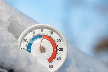 Outdoor thermometer in snow shows sub-zero temperature winter weather concept