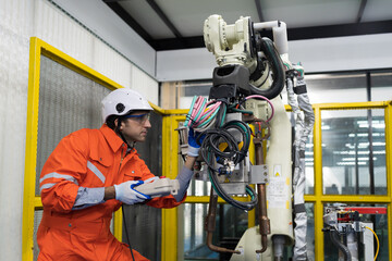 Male engineer repair or maintenance automatic robot arm system in the manufacturing automation and...