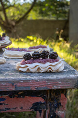 Dessert Anna Pavlova with fresh blackberries and buttercream.