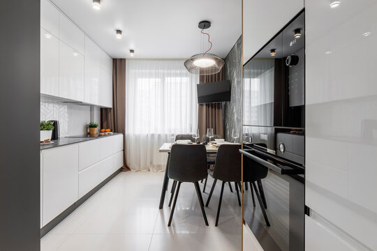Modern cuisine in black in the dining table and kitchen appliances