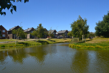 Obraz premium a beautiful river near a housing estate in the summer time