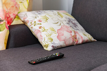 The remote control from the TV lies on the couch