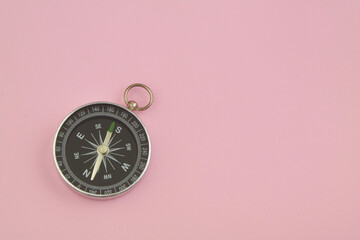 Round compass on pink background with copy space for text. Travel and navigation concept.