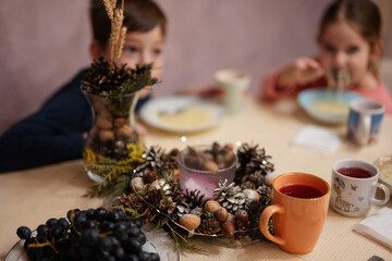 Kids have dinner together in the kitchen. Christmas table.