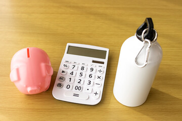 ラテマネーのイメージ。水筒と豚の貯金箱と電卓
