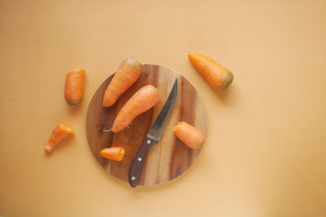 fresh carrots on chopping board on table 