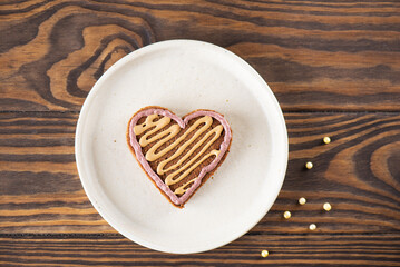 Heart shaped gingerbread in a plate on a wooden background. Healthy food, sugar, gluten and lactose free.