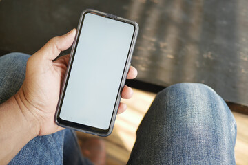 young man hand using smart phone with green screen at cafe 