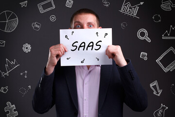 Business, Technology, Internet and network concept. Young businessman working on a virtual screen of the future and sees the inscription: SAAS