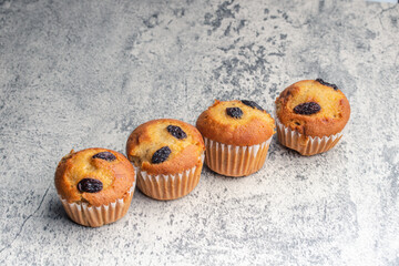 Banana cupcakes sprinkled with raisins. Copy space on gray background.