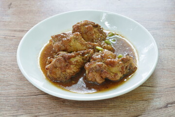 fried chicken drumsticks with garlic and black pepper gravy sauce stew on plate