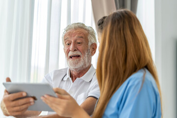 Man being cared for by a private Asian nurse at home suffering from Alzheimer's disease to closely care for elderly patients with copy space on left