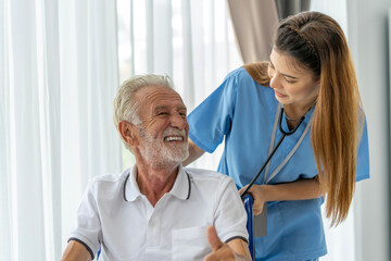 Man being cared for by a private Asian nurse at home suffering from Alzheimer's disease to closely care for elderly patients with copy space on left