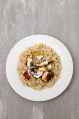 Cooked quinoa with vegetables and sauce on white plate