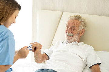Obraz premium Man being cared for by a private Asian nurse at home suffering from Alzheimer's disease to closely care for elderly patients with copy space on left
